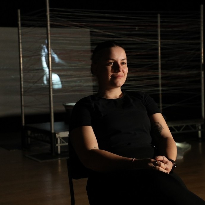 Elicia Axon sitting in a chair on set